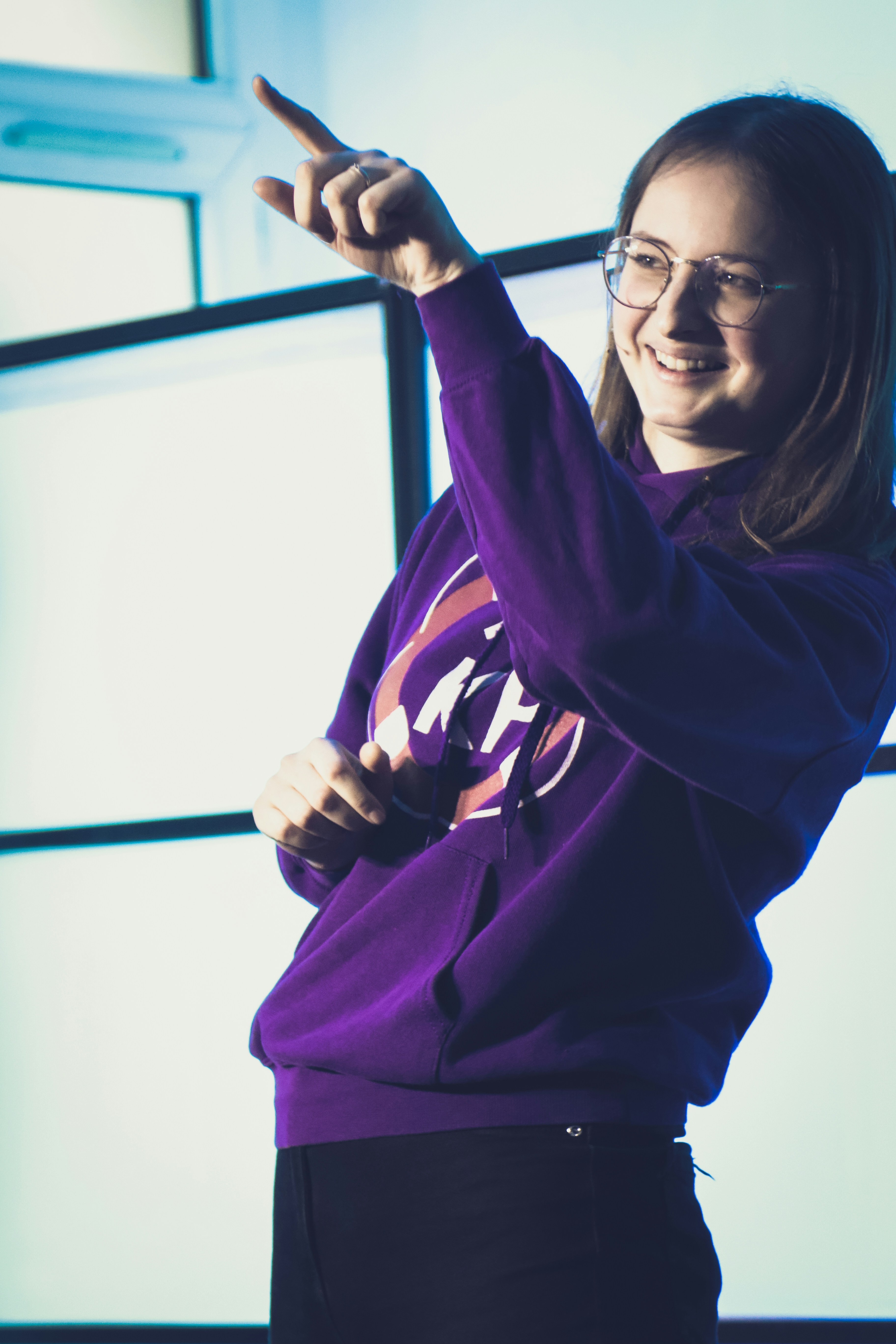 A woman in a purple shirt pointing at something