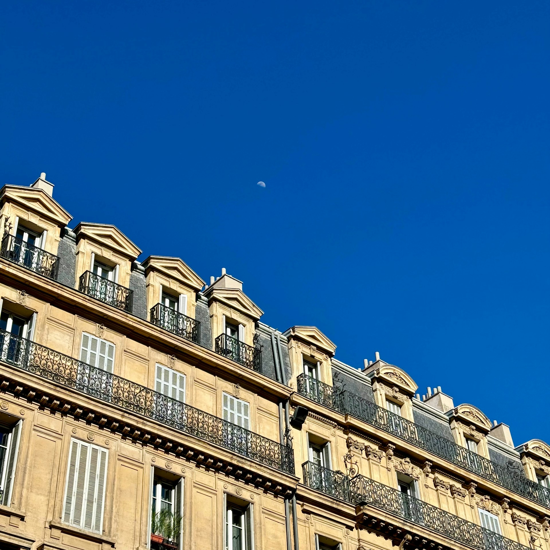 Parisian building against a bright blue sky.
