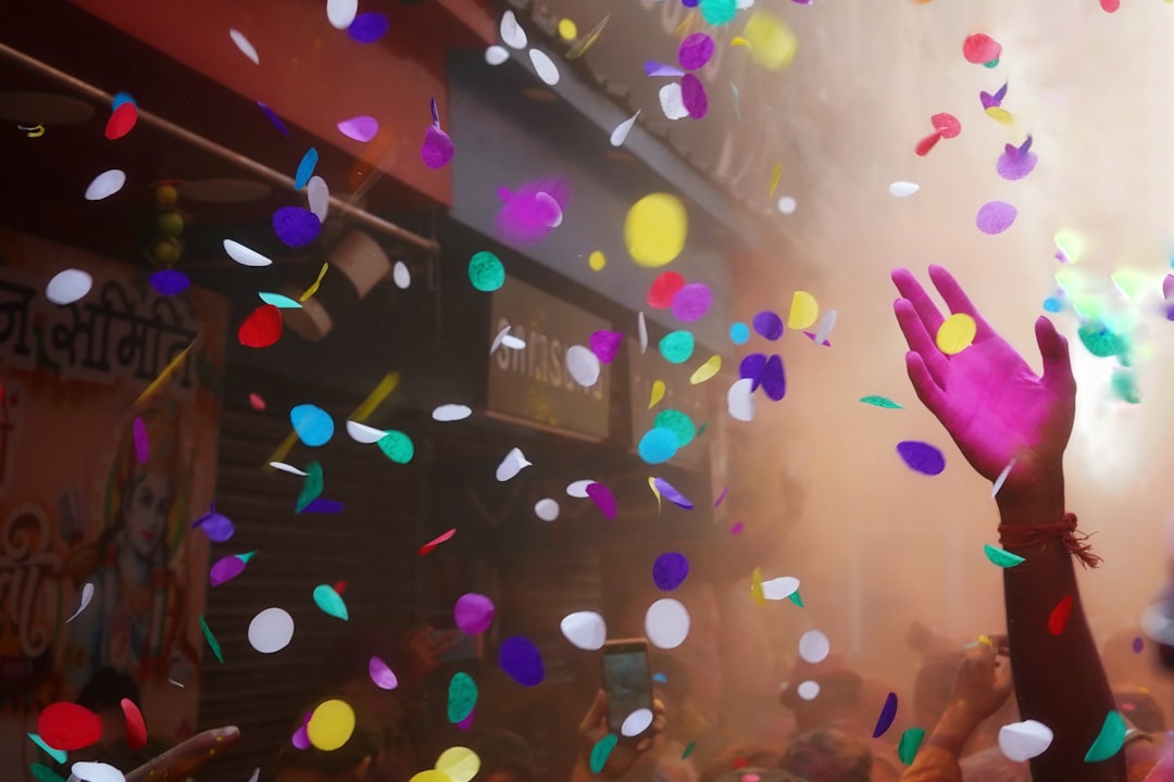 A crowd of people are throwing confetti in the air,