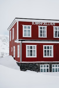 A red building with white windows in the snow