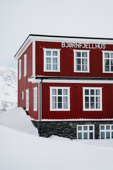 A red building with white windows in the snow