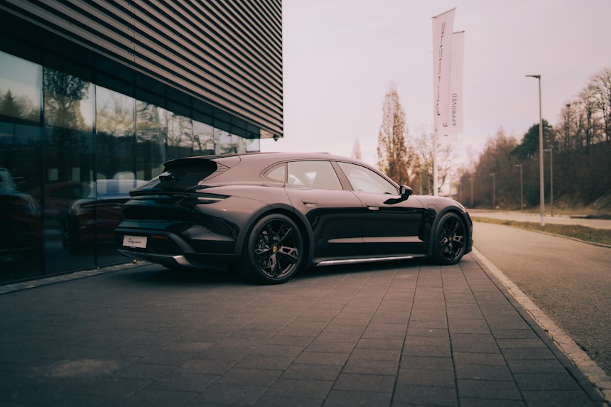 Electric touring estate parked beside a modern building — photo by Tikva on Unsplash