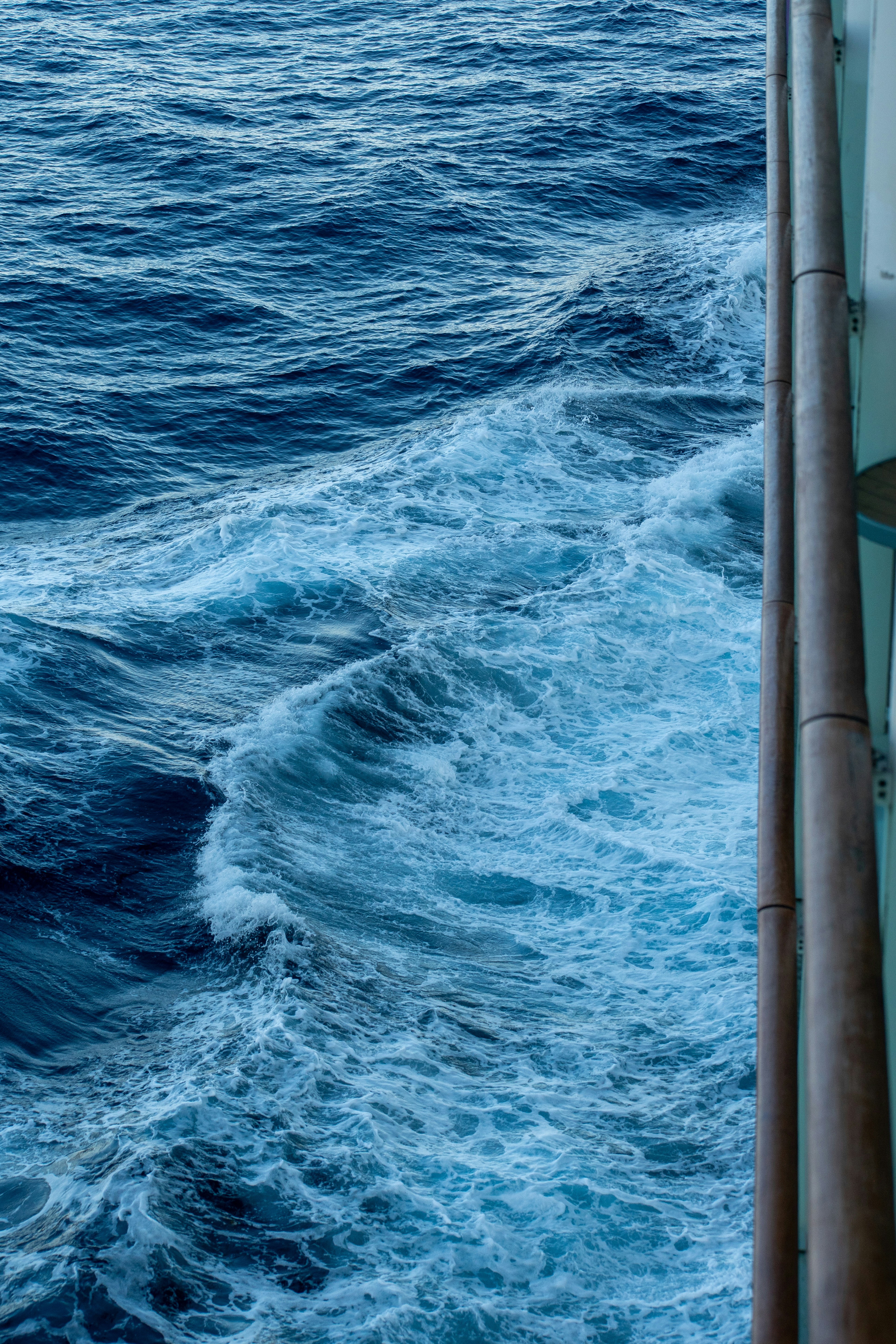 Ocean waves crashing beside a ship.