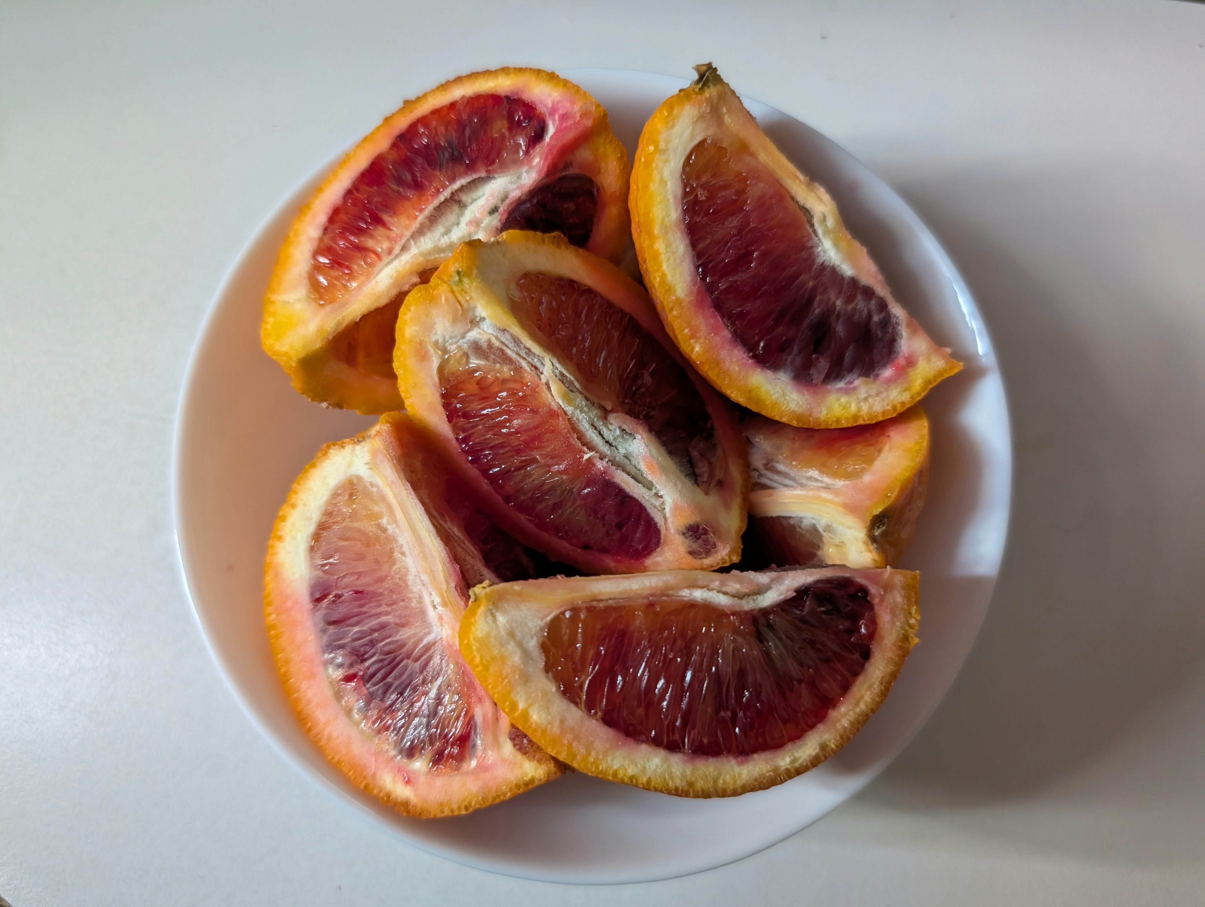 Freshly sliced blood oranges in a bowl.