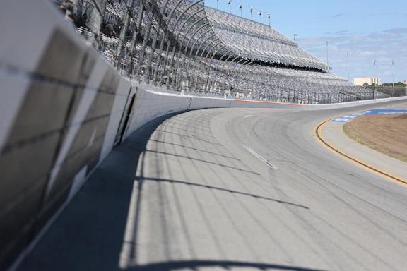 A racetrack curve and grandstands are shown.