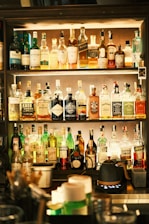 Bar shelves stacked with various alcoholic beverages.
