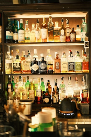 Bar shelves stacked with various alcoholic beverages.