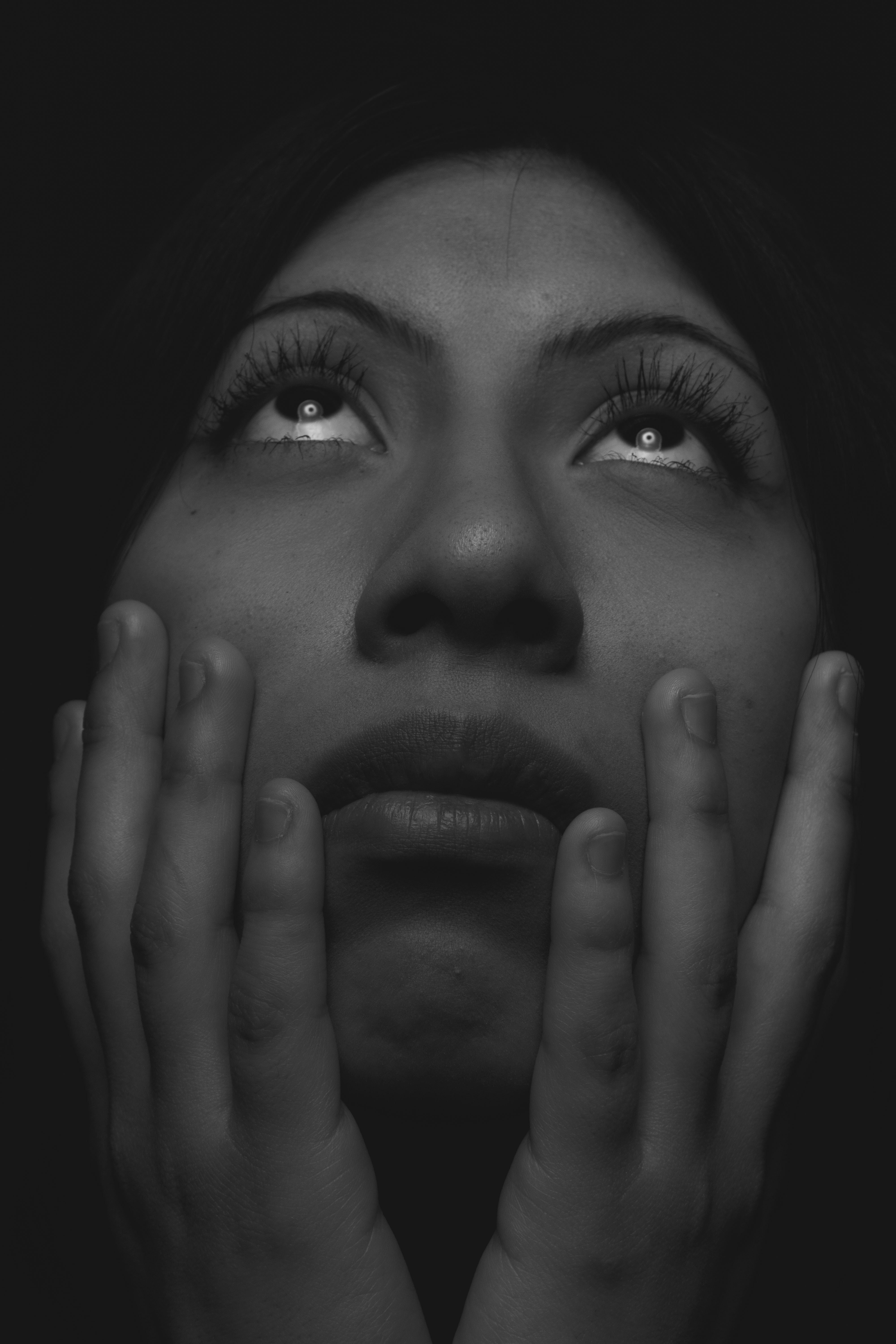 Woman looking up with hands on her face