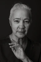 An elderly woman is posing for a portrait.