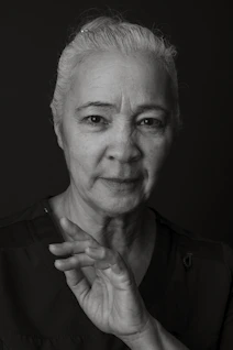 An elderly woman is posing for a portrait.