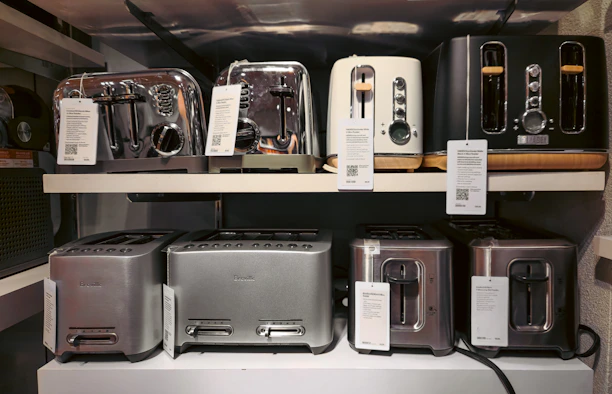 A bunch of toasters that are on a shelf
