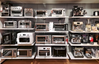 A room filled with lots of different types of microwaves