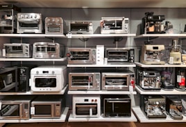 A bunch of microwaves that are on a shelf
