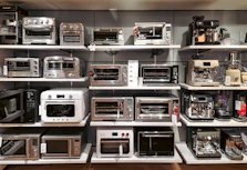 A bunch of microwaves that are on a shelf