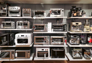 A bunch of microwaves that are on a shelf