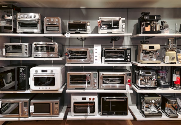 A bunch of microwaves that are on a shelf