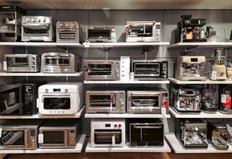 A bunch of microwaves that are on a shelf