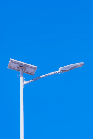 Solar-powered streetlight against a bright blue sky.