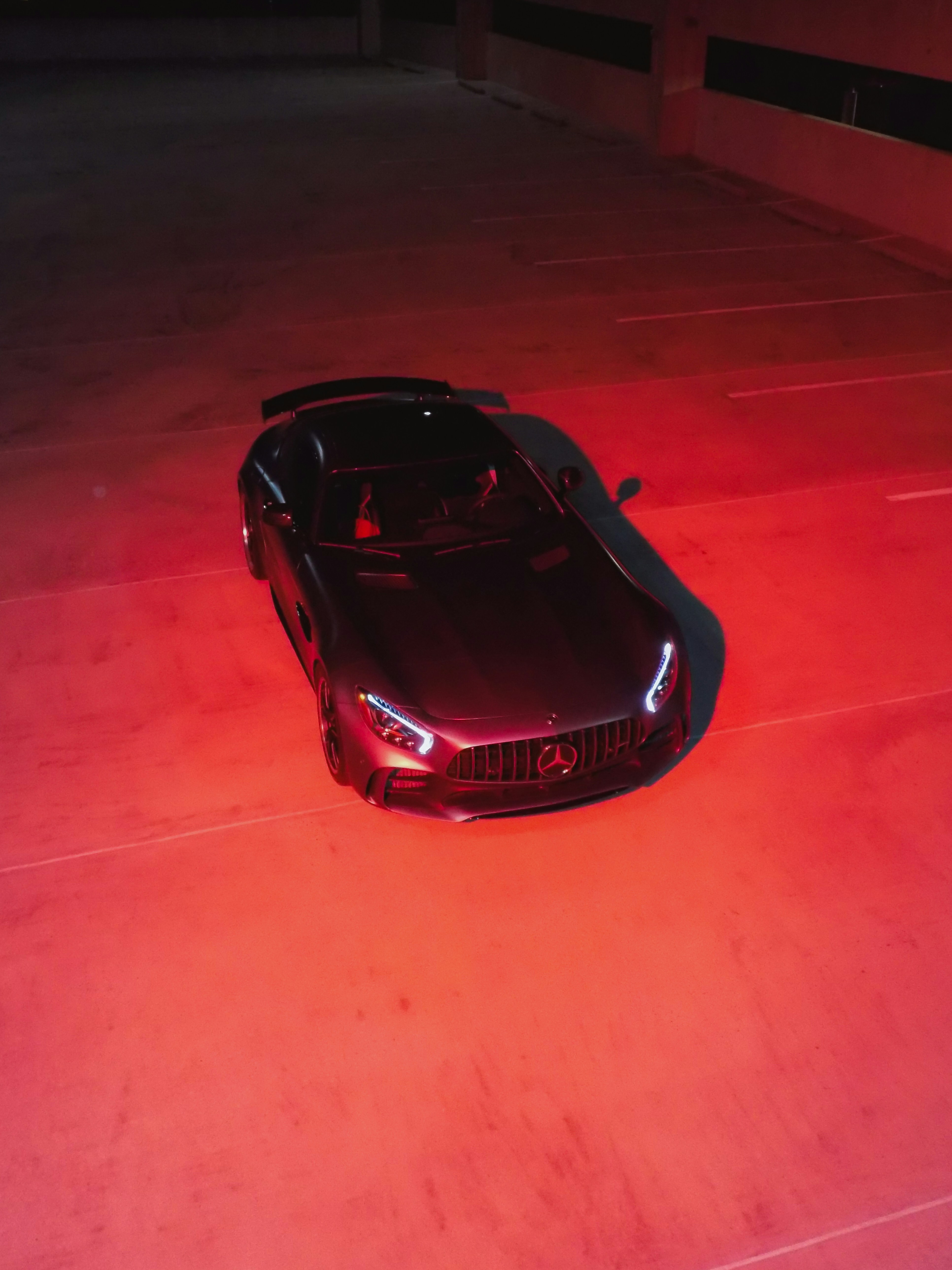 Mercedes-benz sports car illuminated by red light.