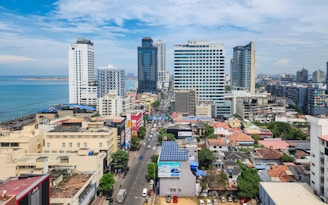 A view of a city with tall buildings and the ocean in the background