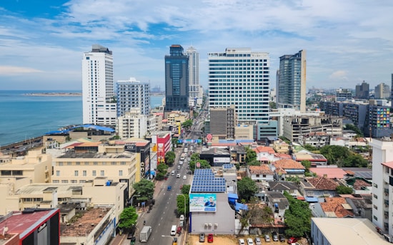 A view of a city with tall buildings and the ocean in the background