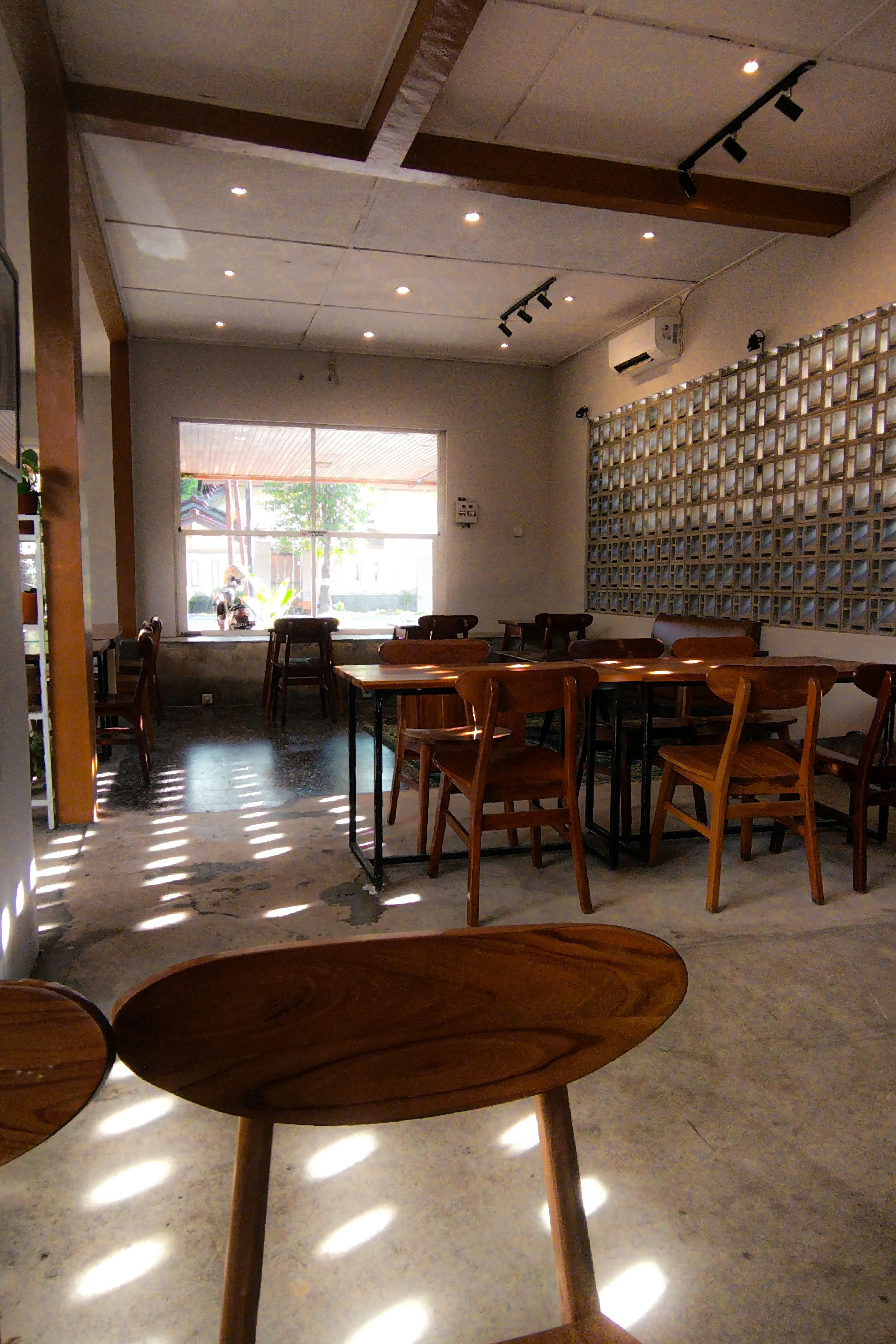 Bright coffee shop interior with wooden tables and sunlight