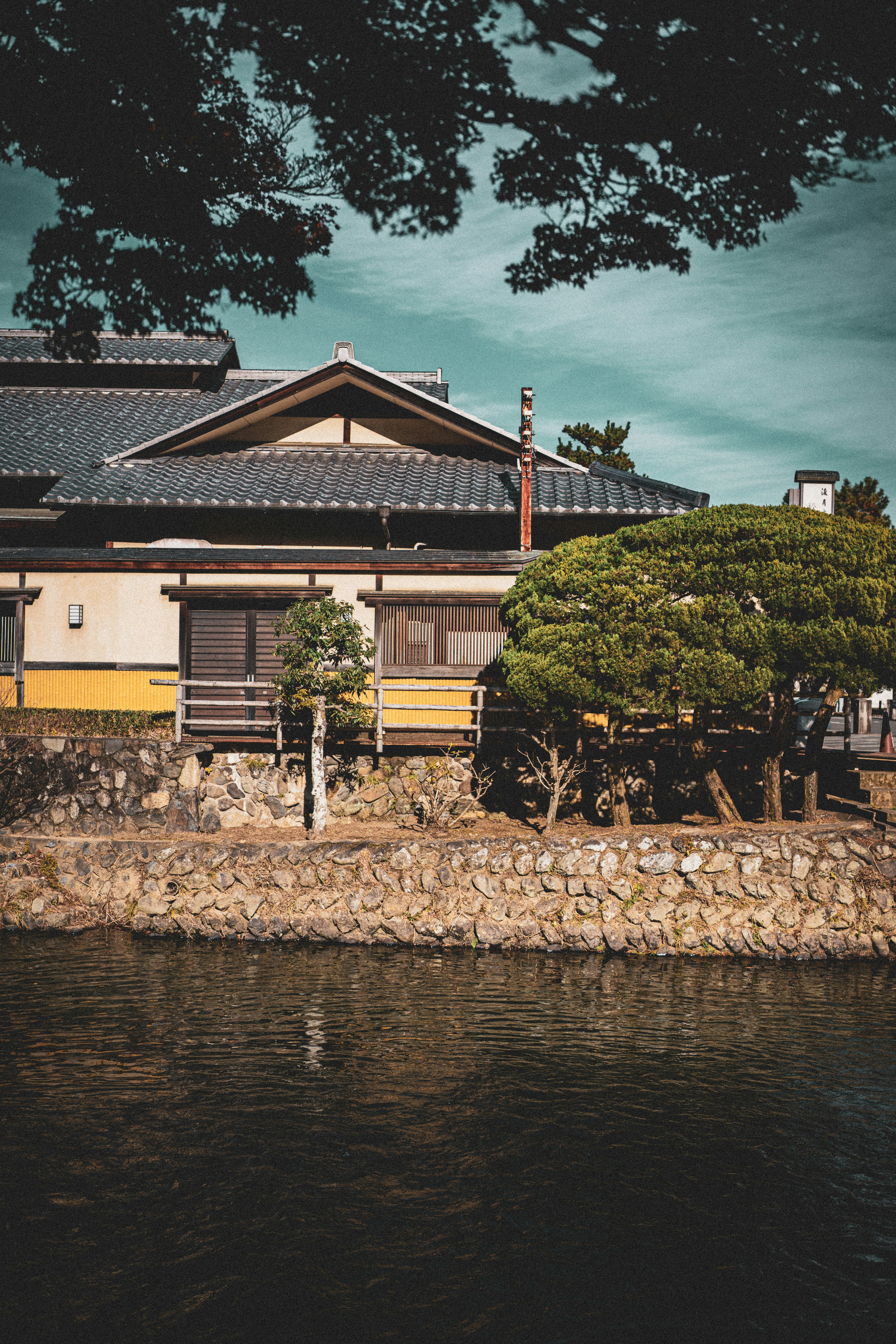 Traditional japanese building next to a body of water.