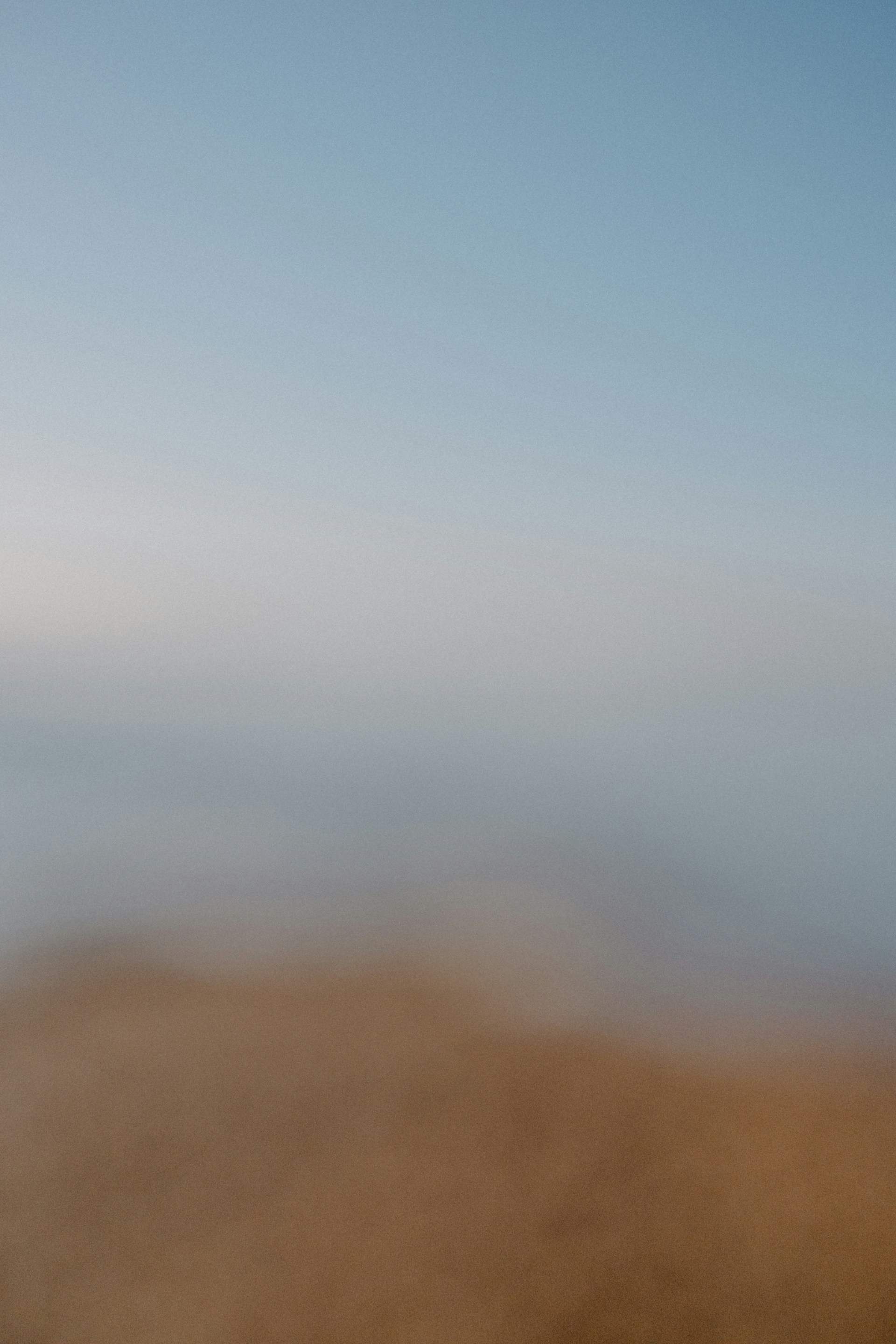 A blurry photo of a beach with a blue sky