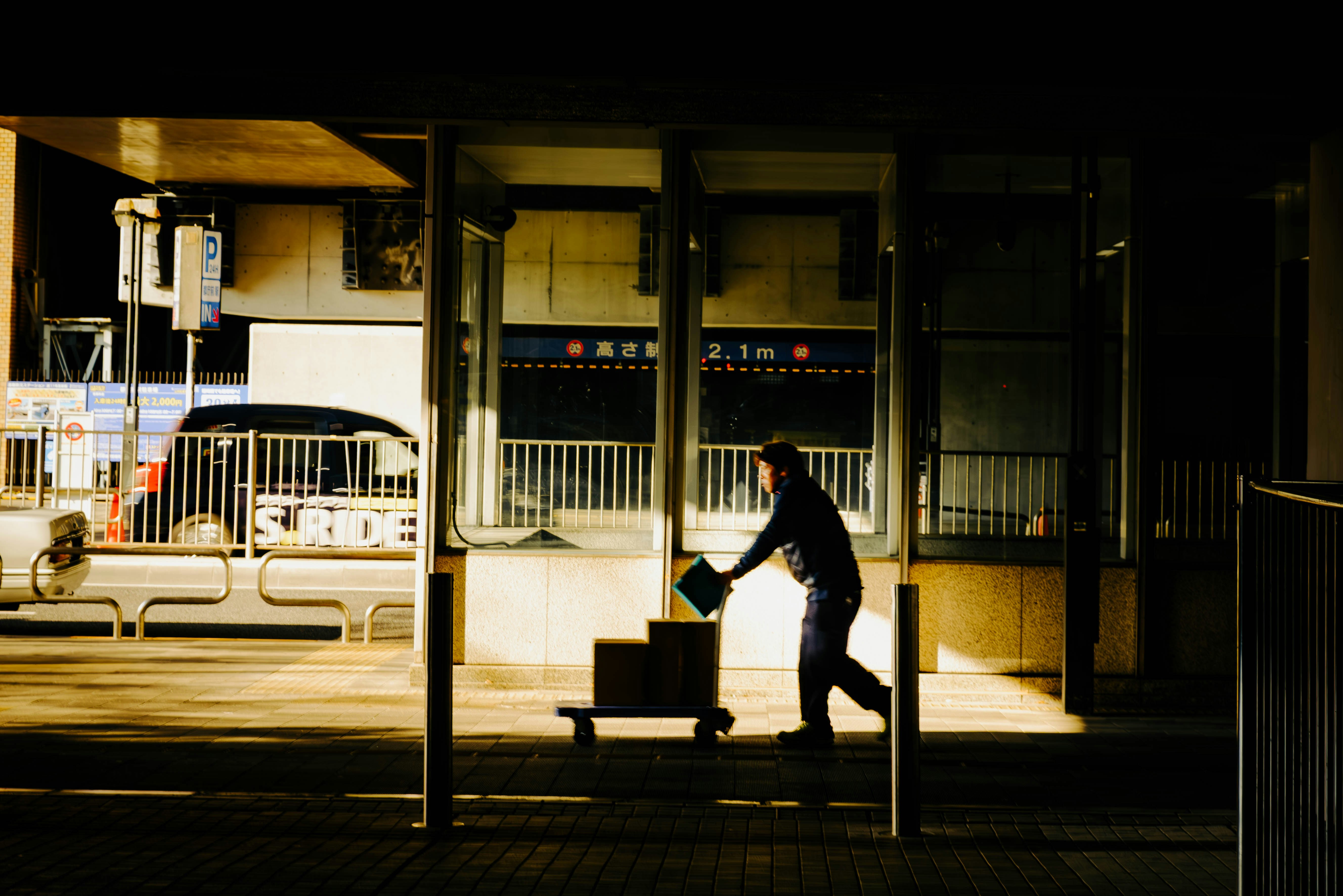 Person dressed warmly waiting at a Japanese train station platform at night