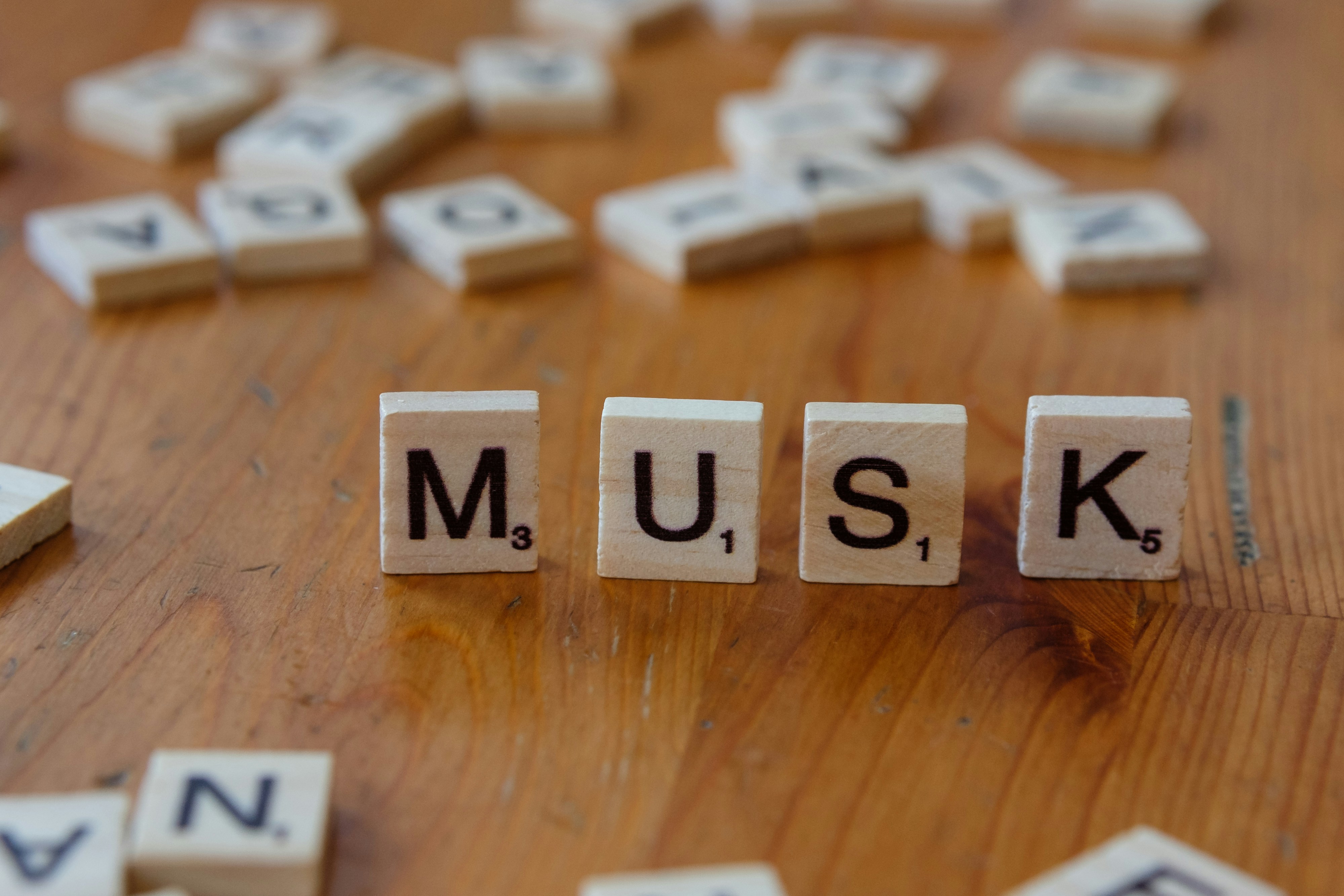 A wooden table topped with scrabble tiles spelling the word music