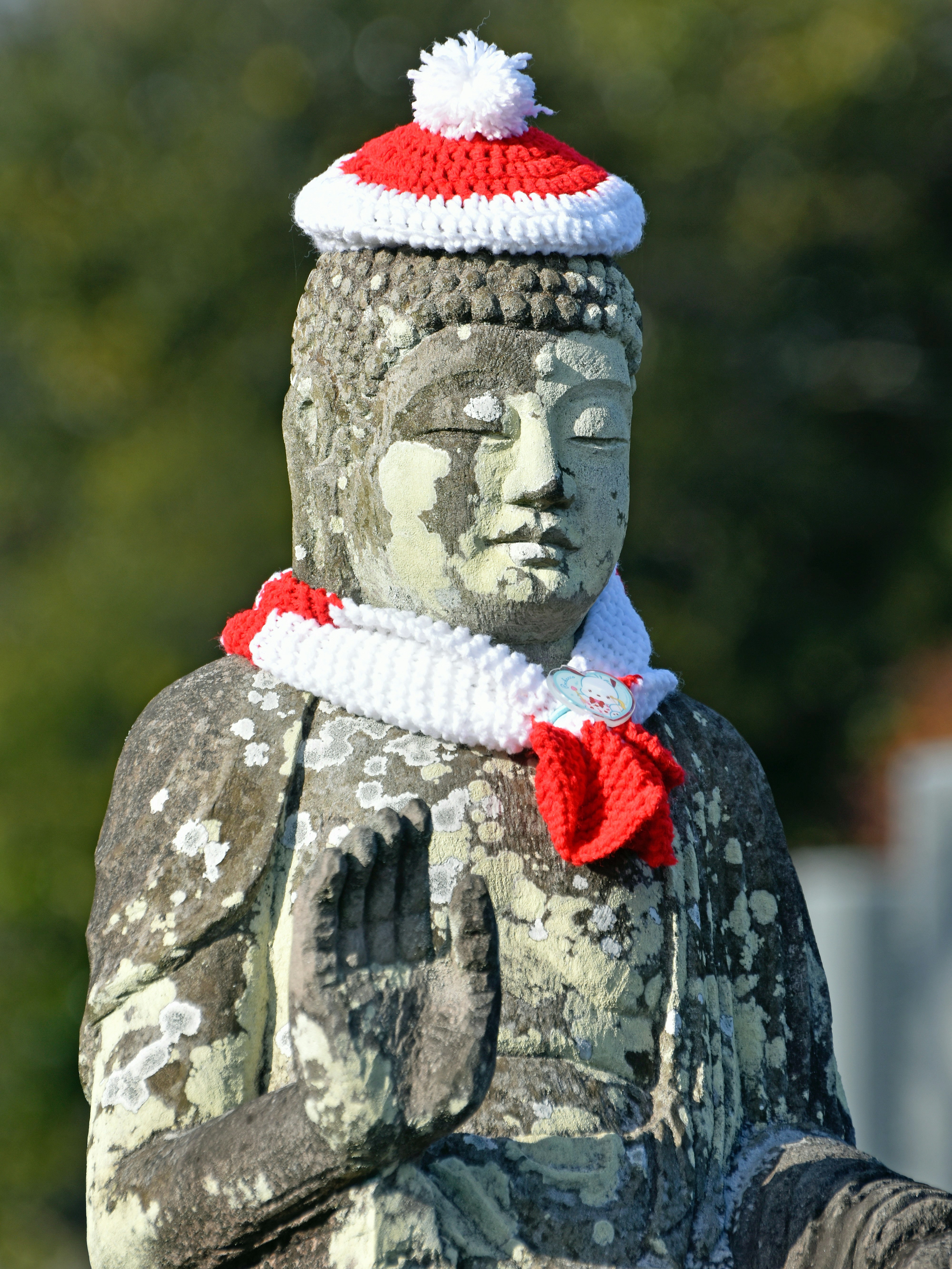 Estatua de Buda con un sombrero festivo y una bufanda.