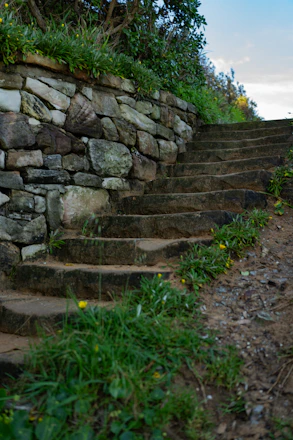 Stone steps lead uphill beside a stone wall.