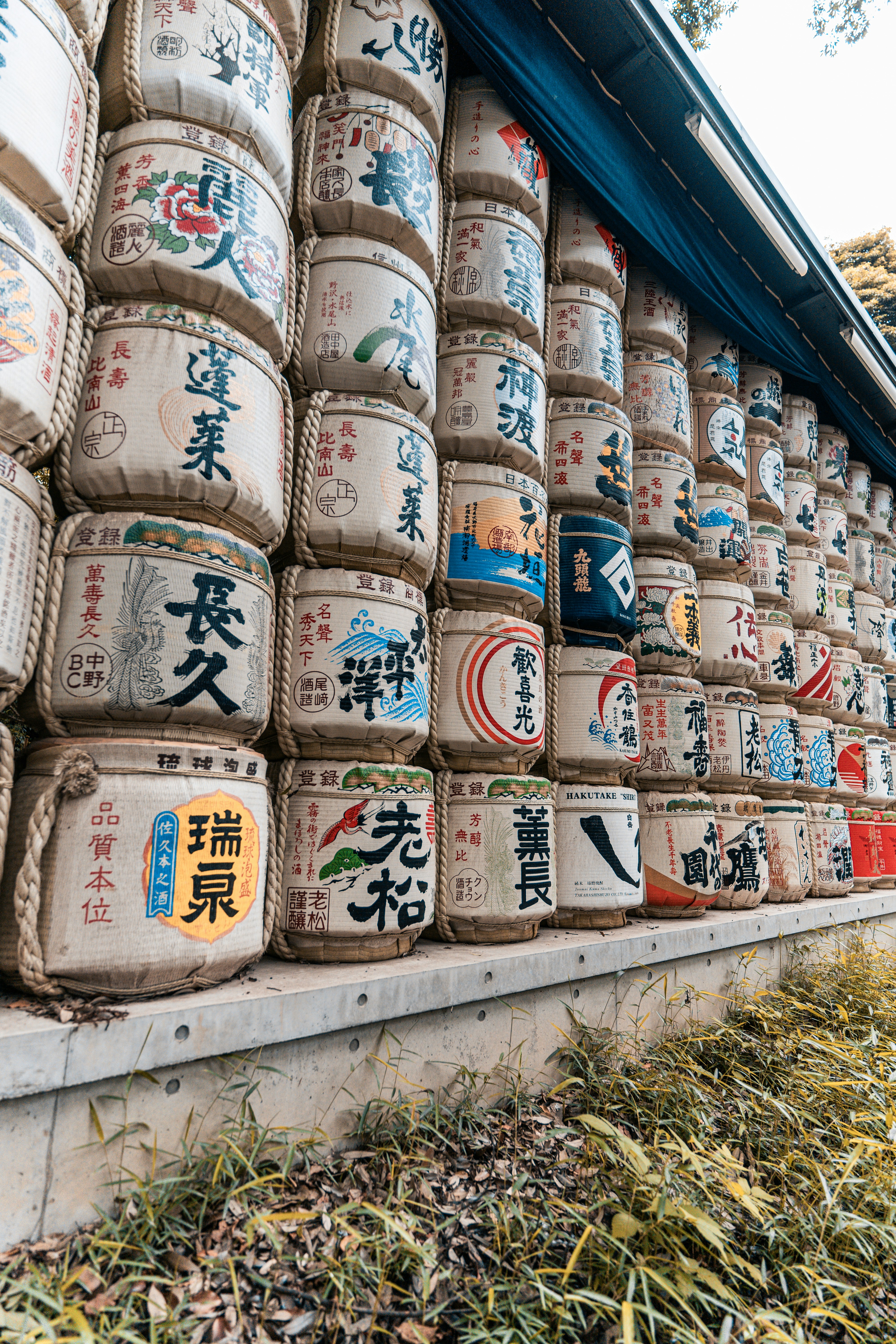 Sake barrels stacked along a building's side.