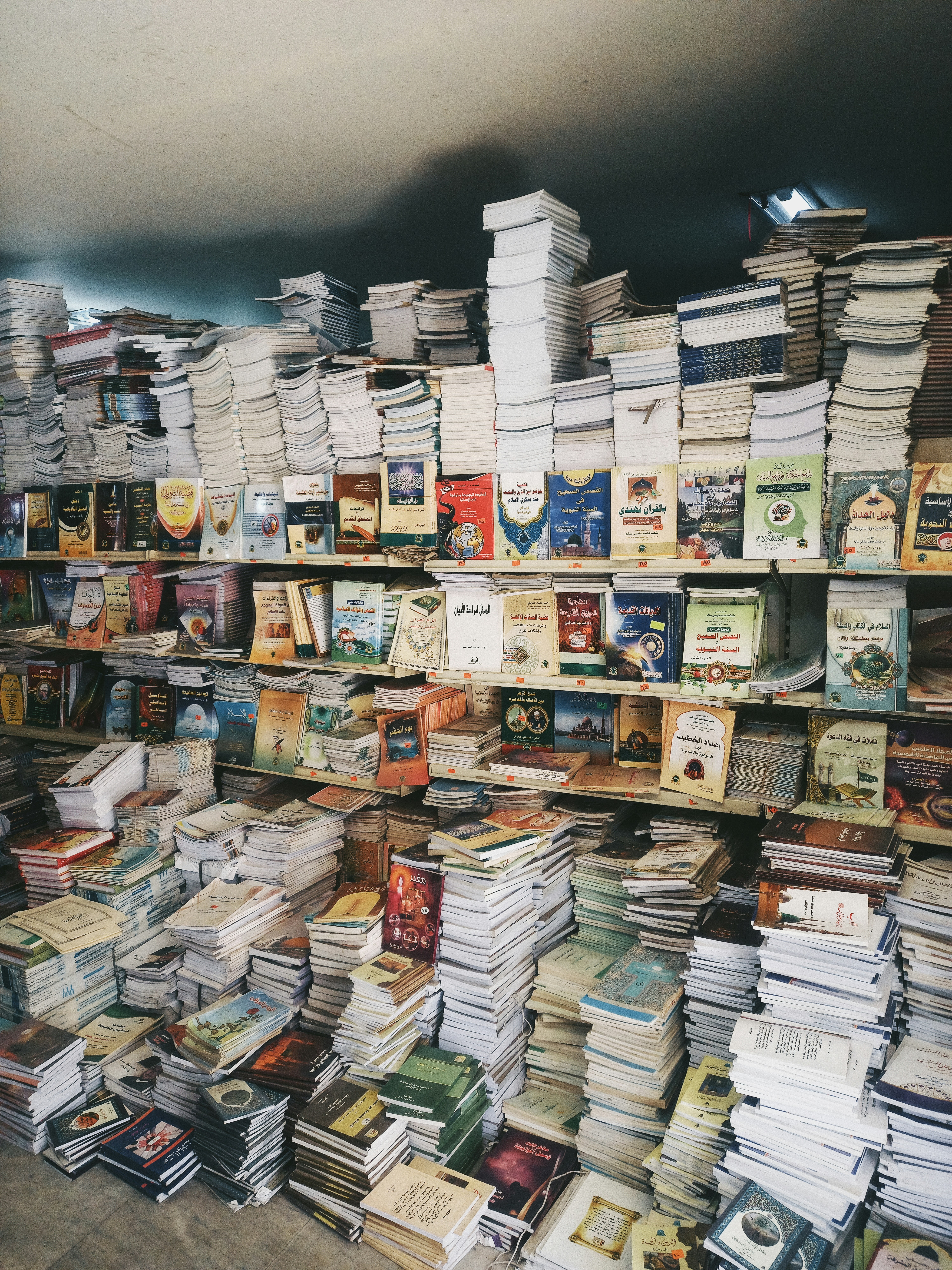 Bookshelves are overflowing with a massive book collection.