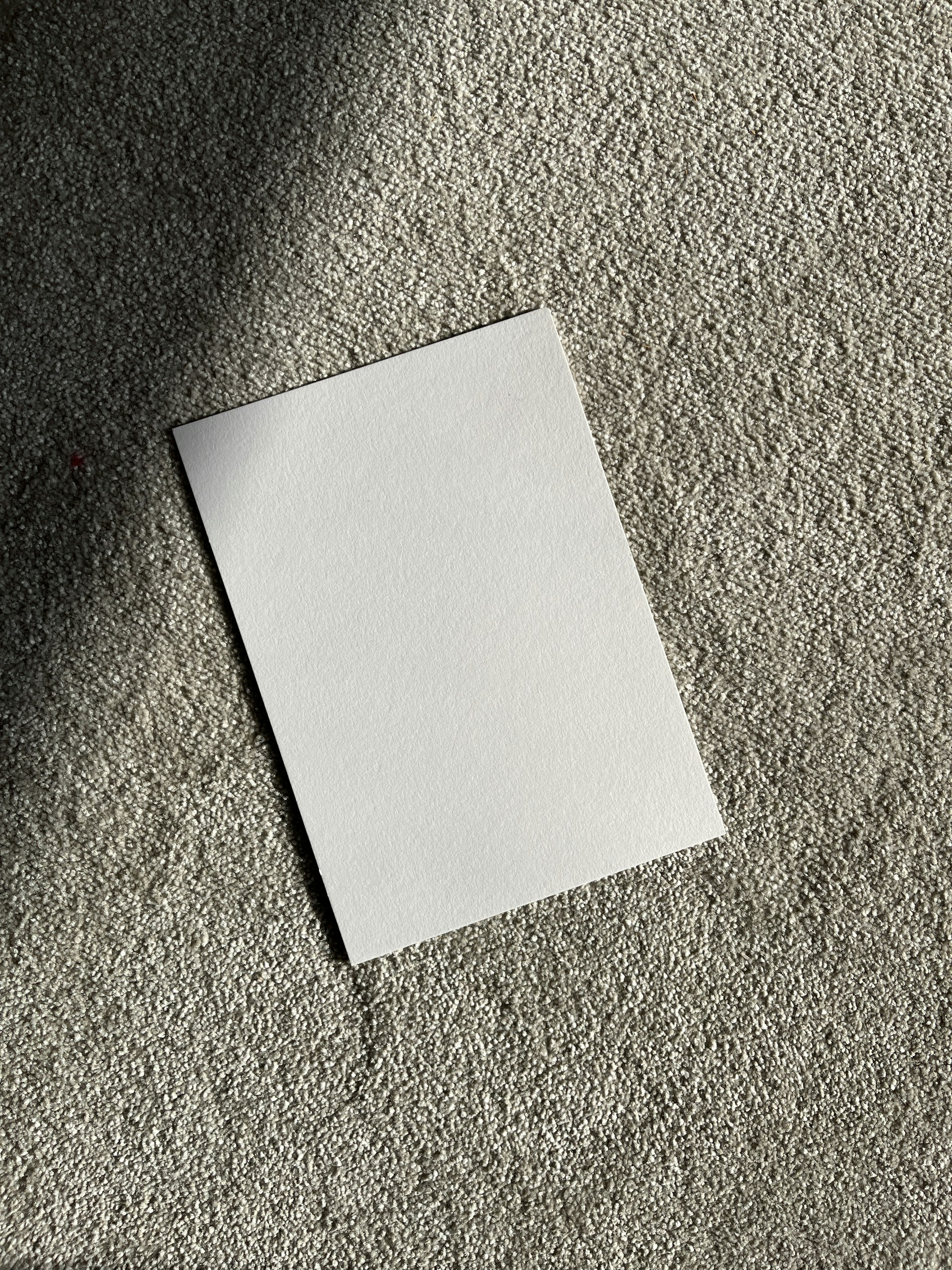 A blank white paper on a textured surface.