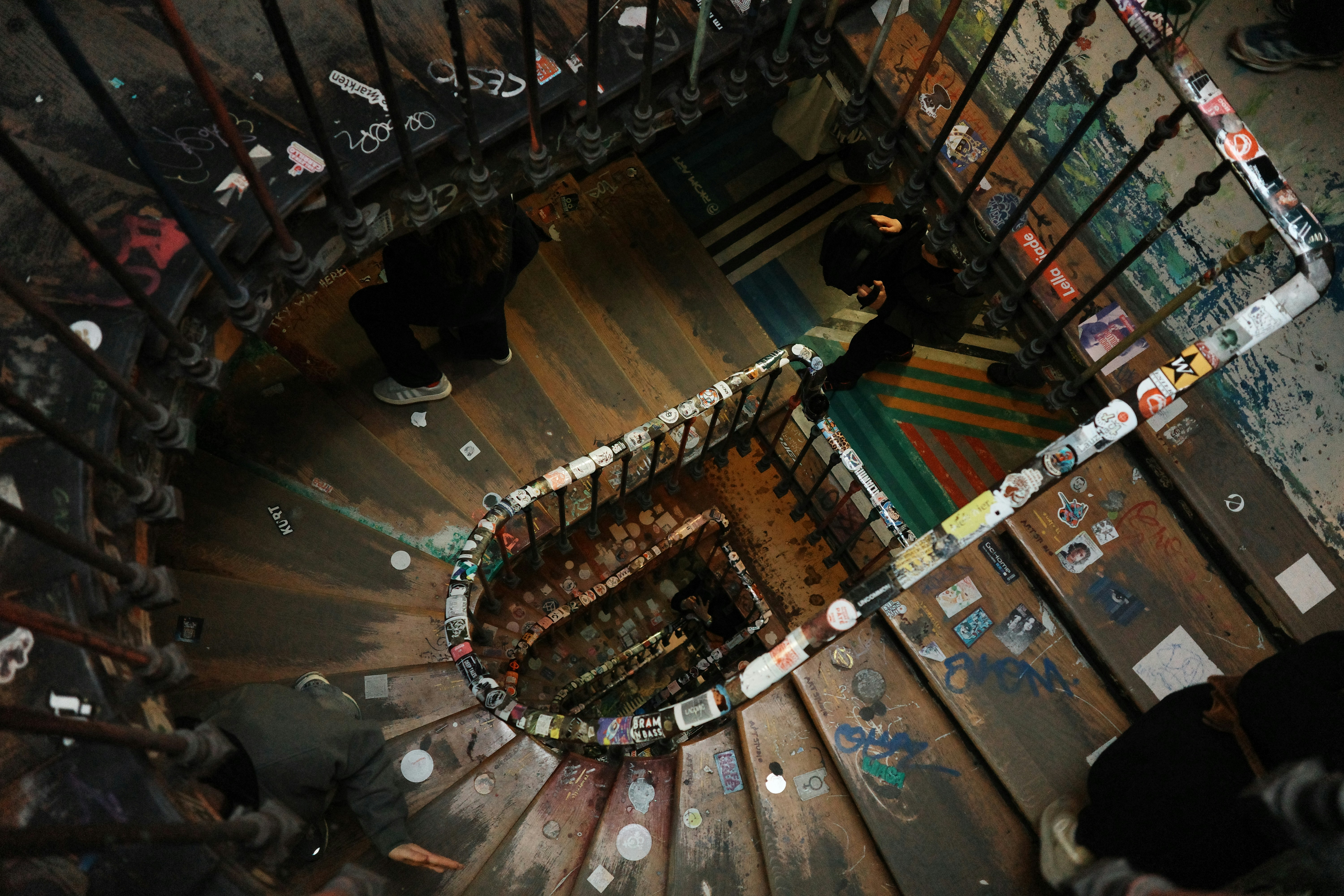 People walk up a spiral staircase from above.