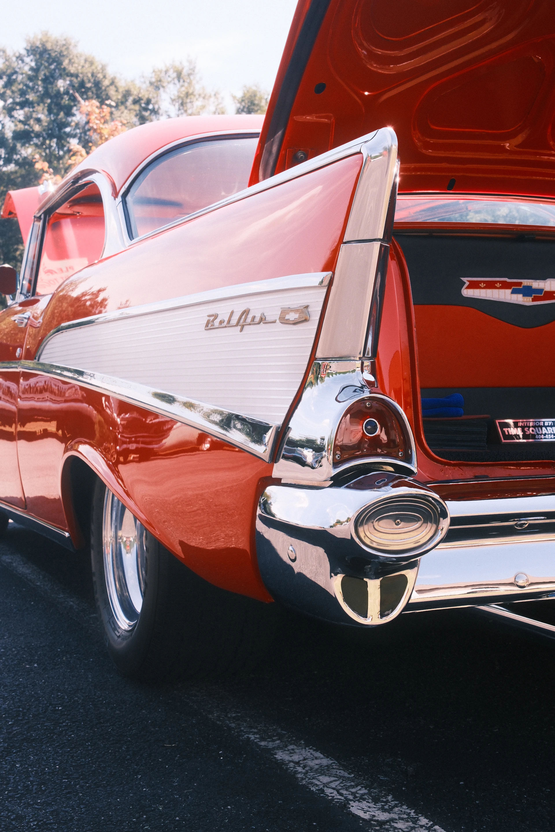 A classic red bel air with open trunk.