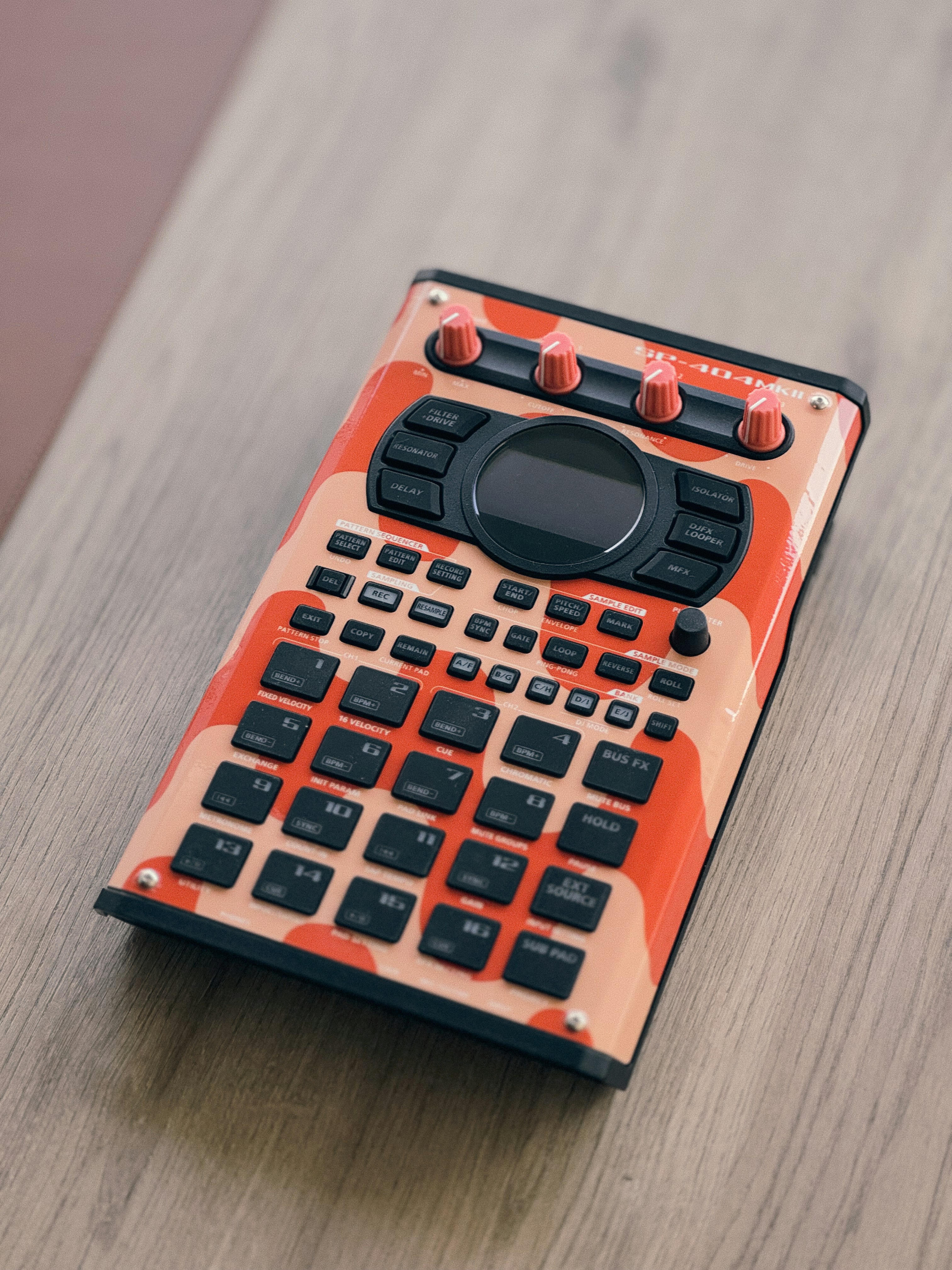 An electronic sampler rests on a wooden surface.