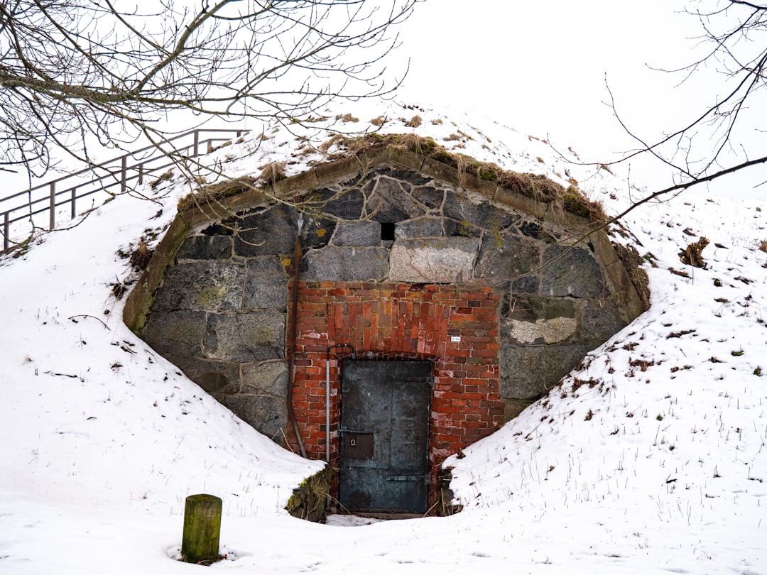 A stone building entrance surrounded by snow.,