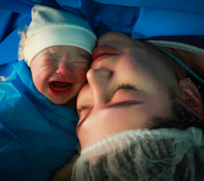 Mother and newborn share an intimate moment.