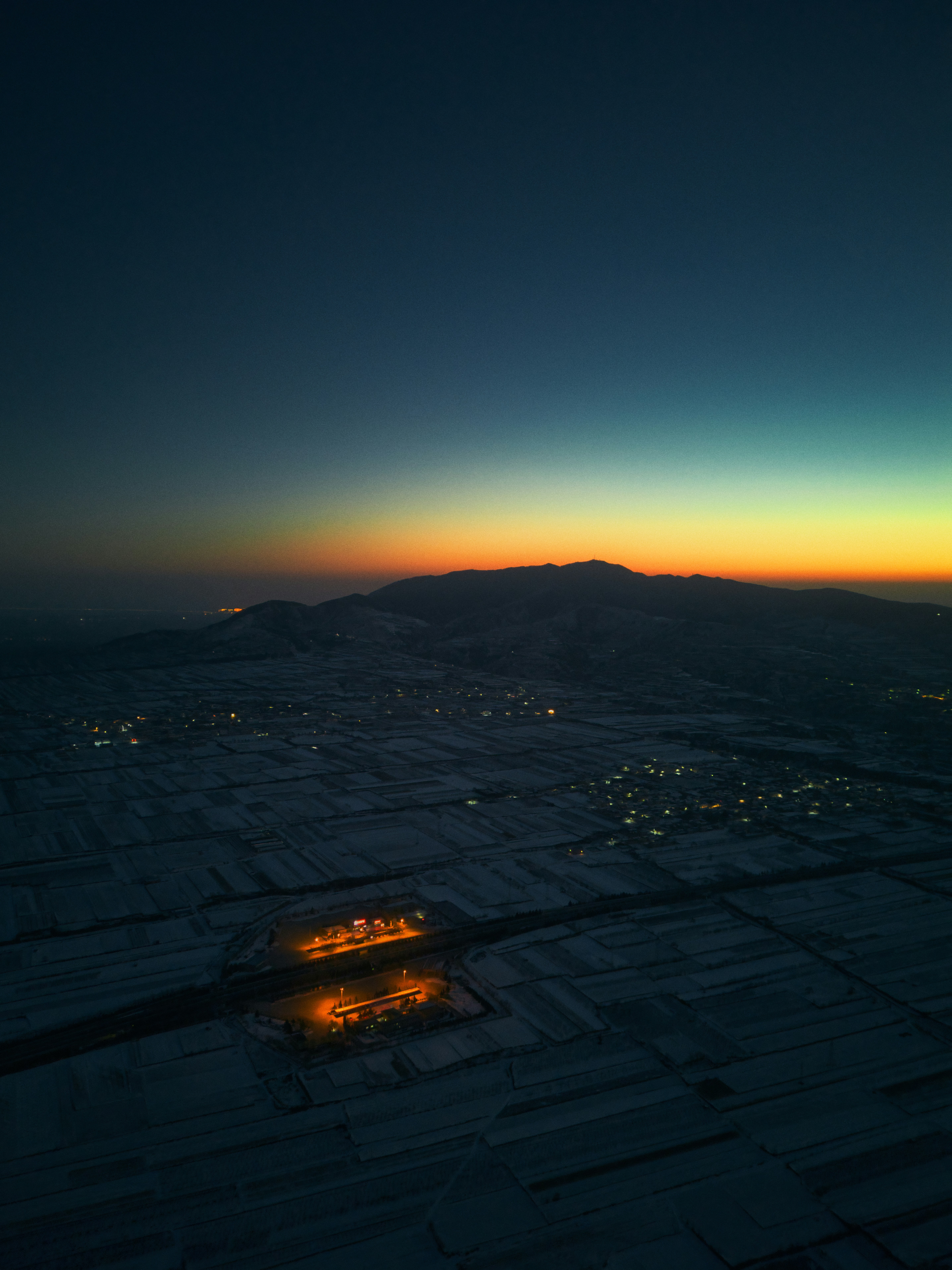 Vue nocturne d’une ville sous la montagne.