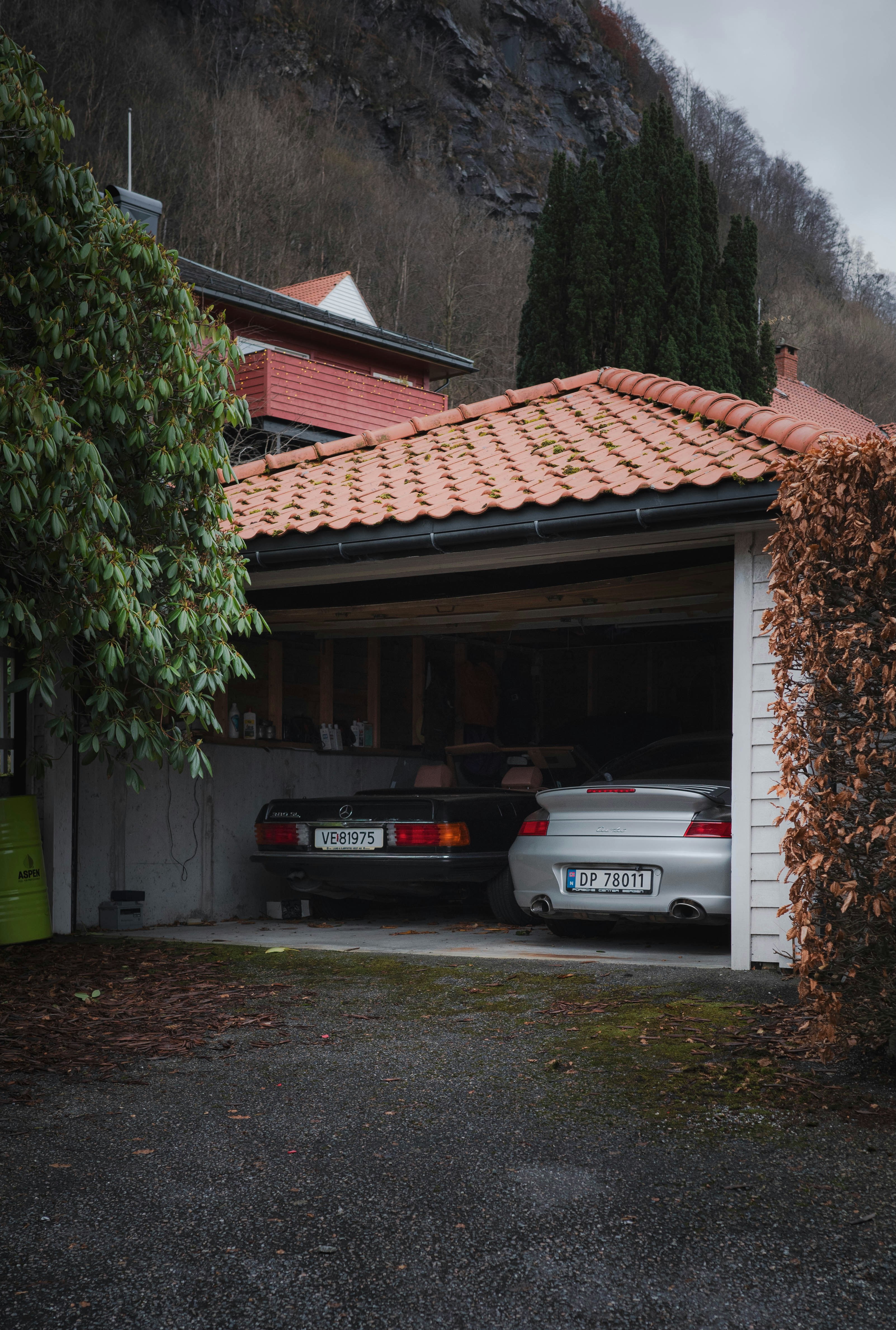 Cars are parked in a garage near a mountain.