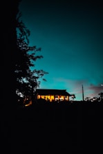 A house with lights glowing against a twilight sky.
