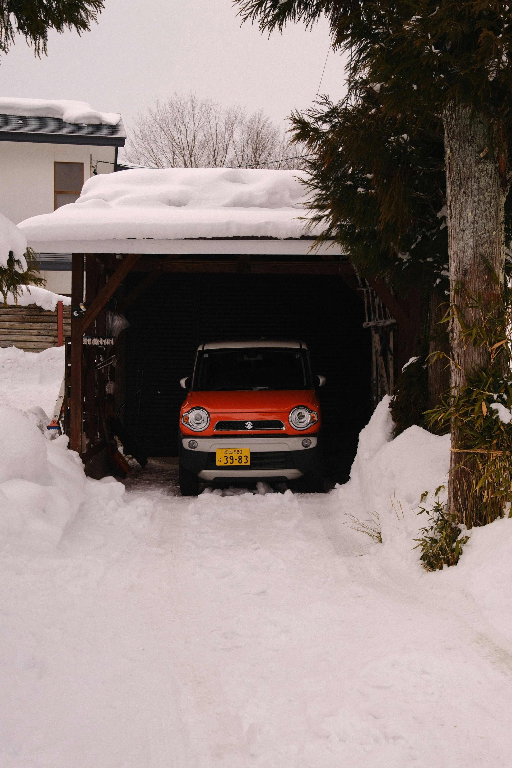 Une voiture orange est garée dans la neige