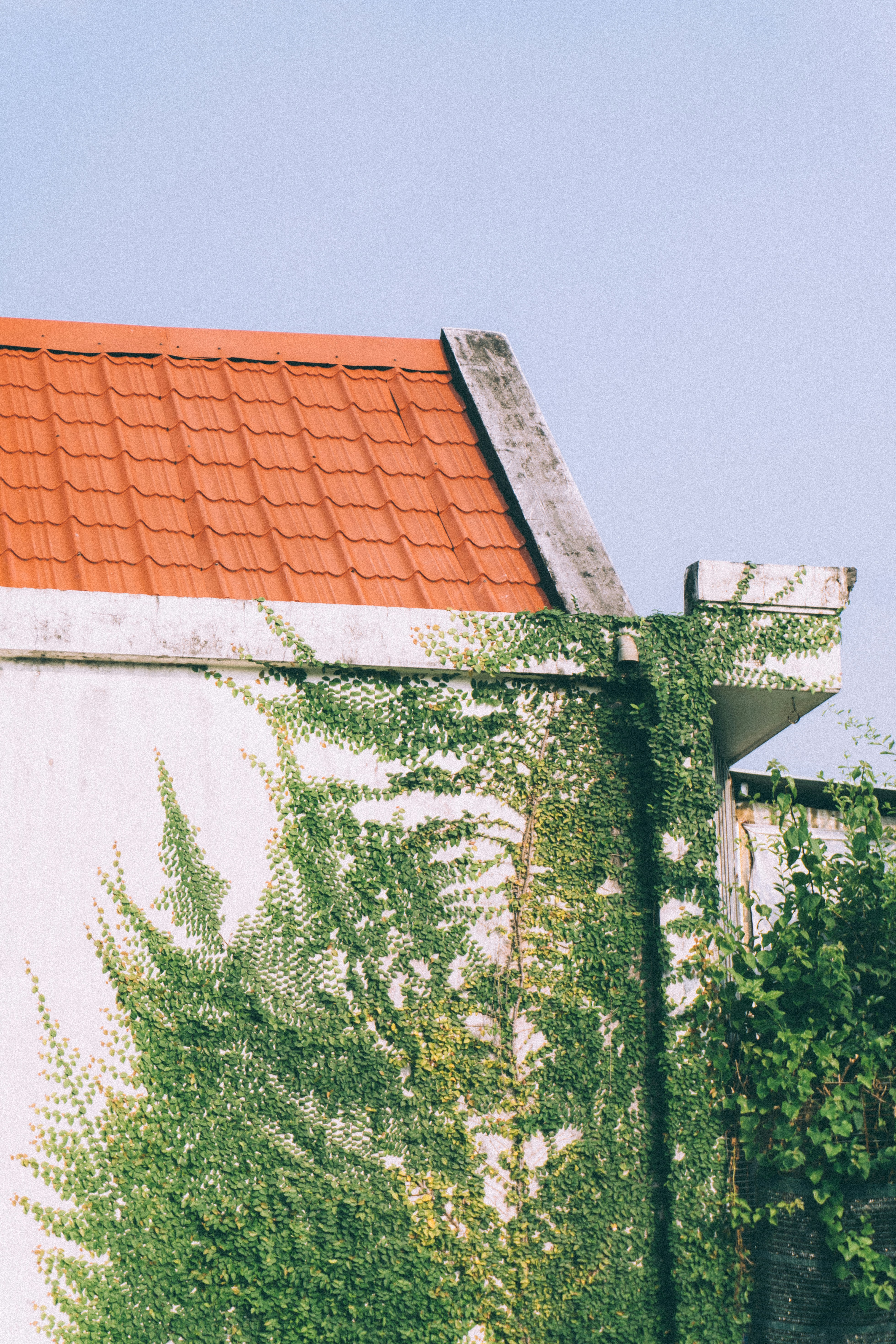 A white building with a red roof and a clock tower