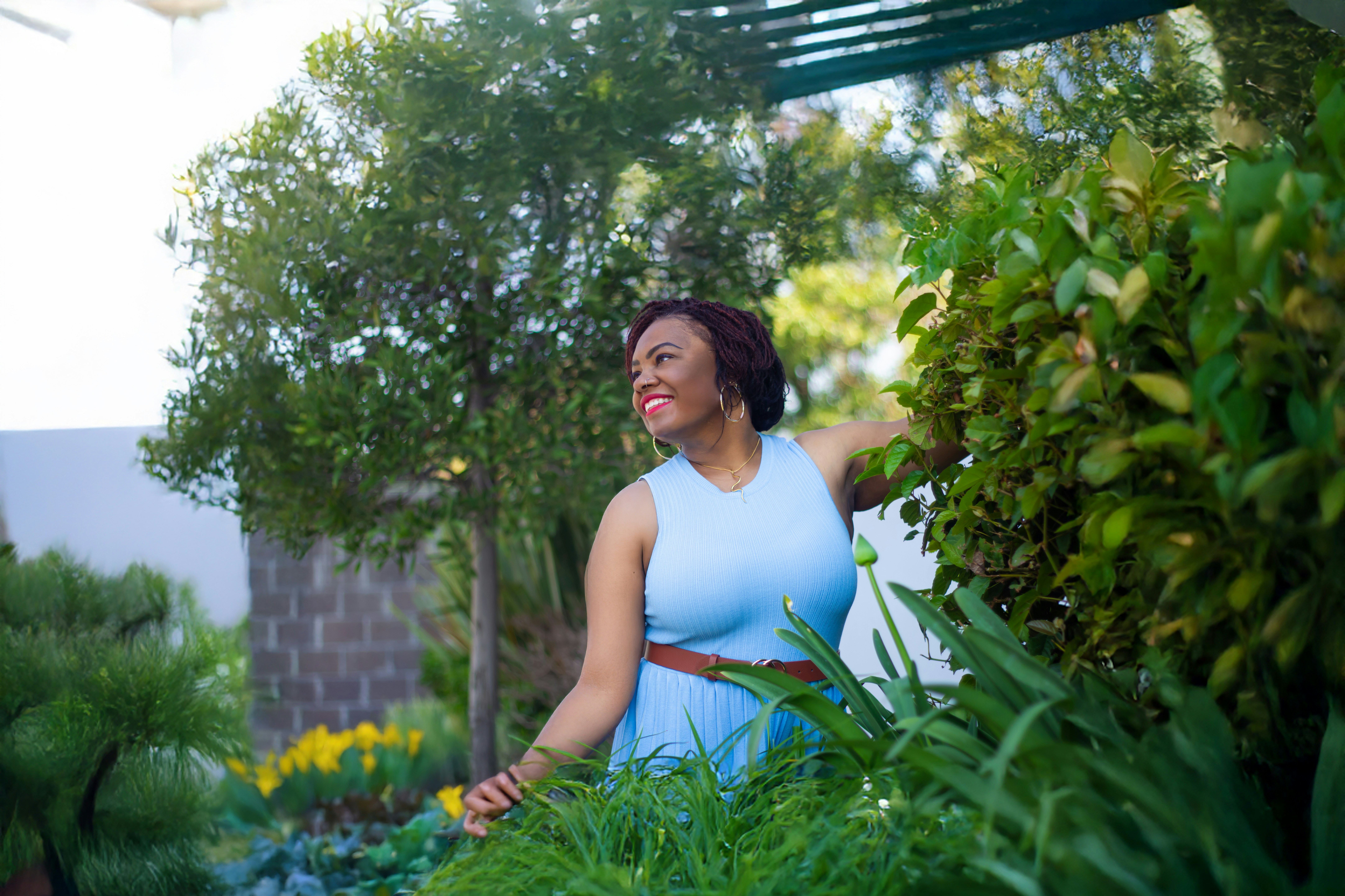 A woman in a blue dress standing in a garden