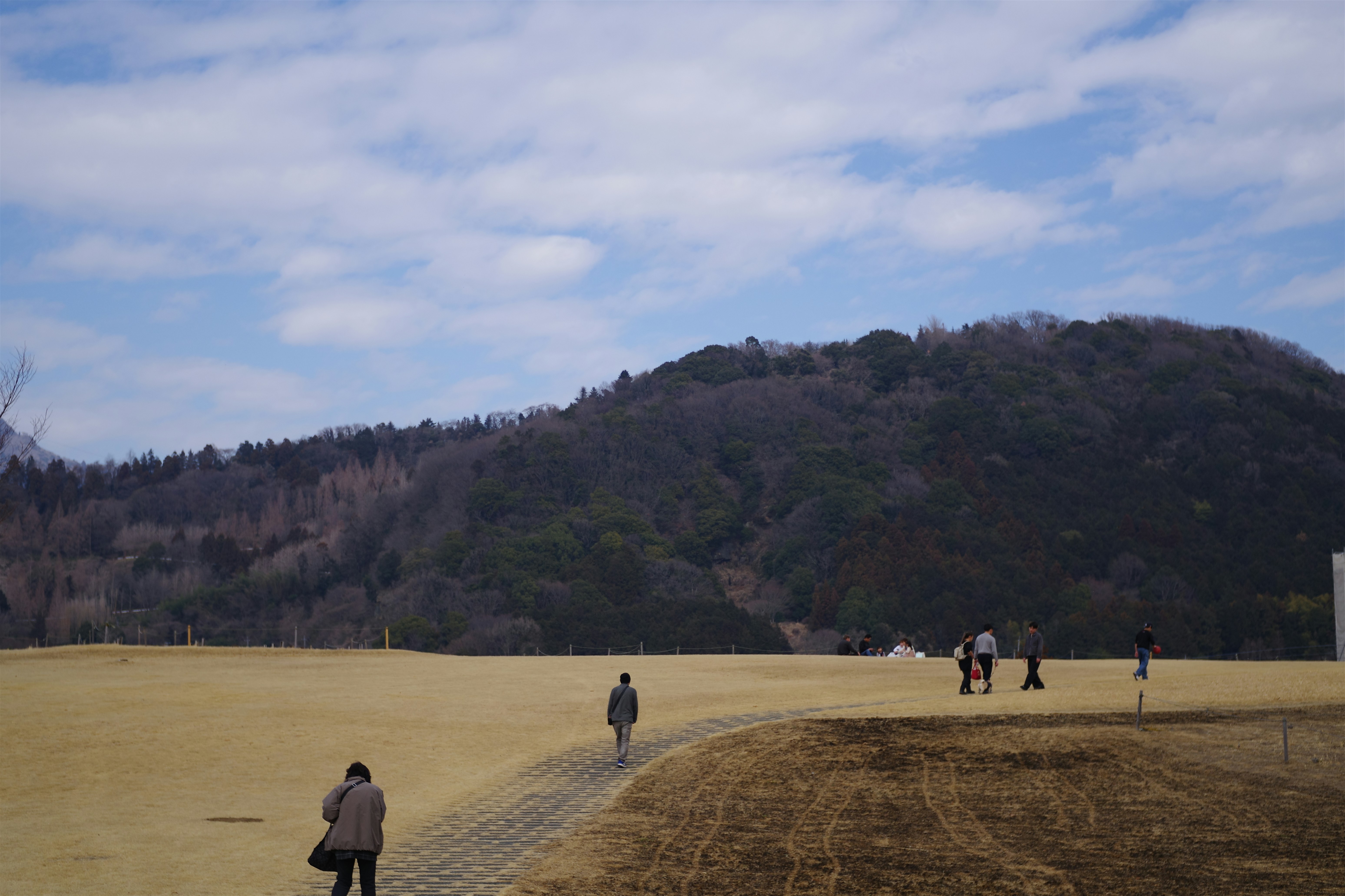 A group of people standing on top of a dry grass field