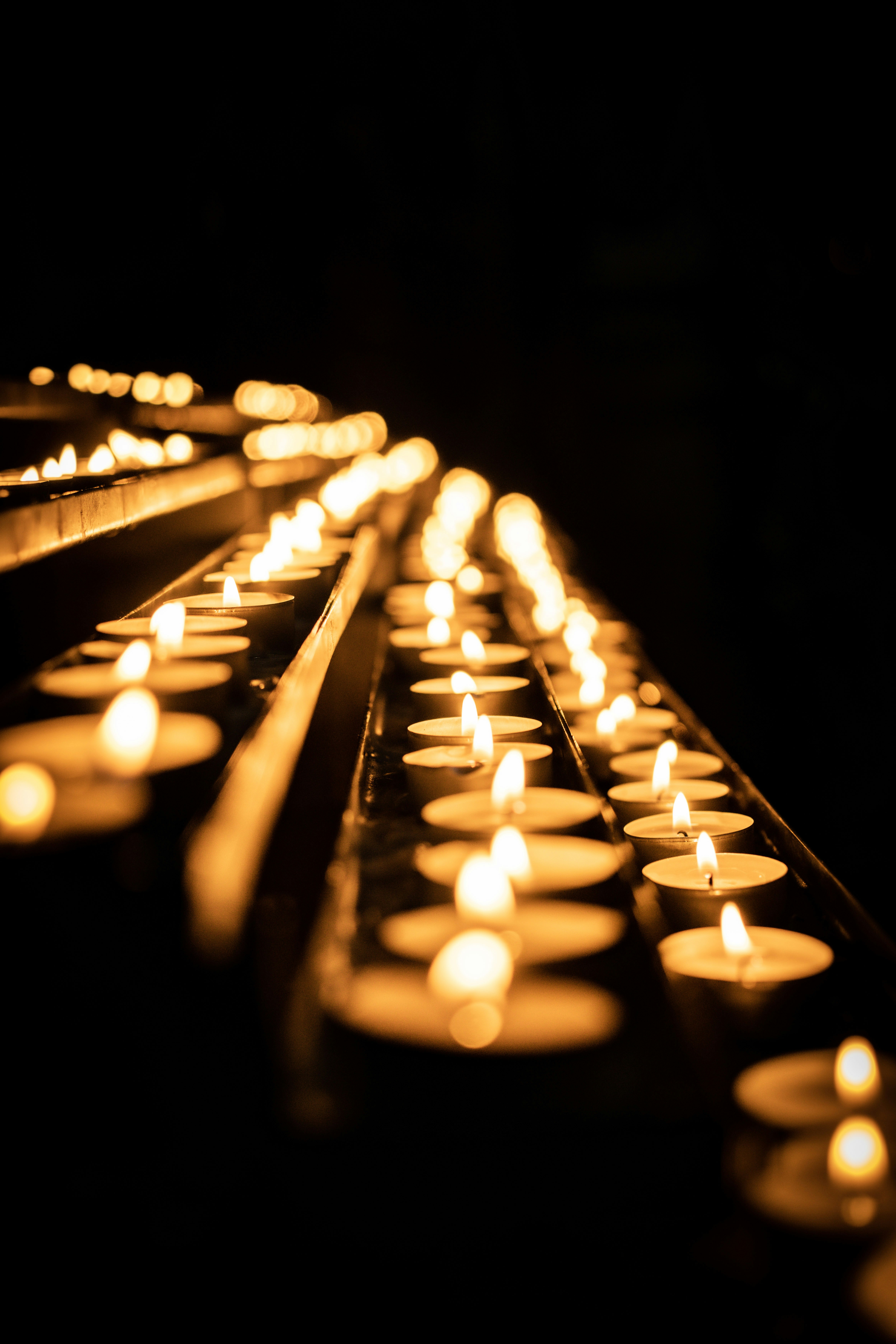 A row of lit candles sitting on top of a table