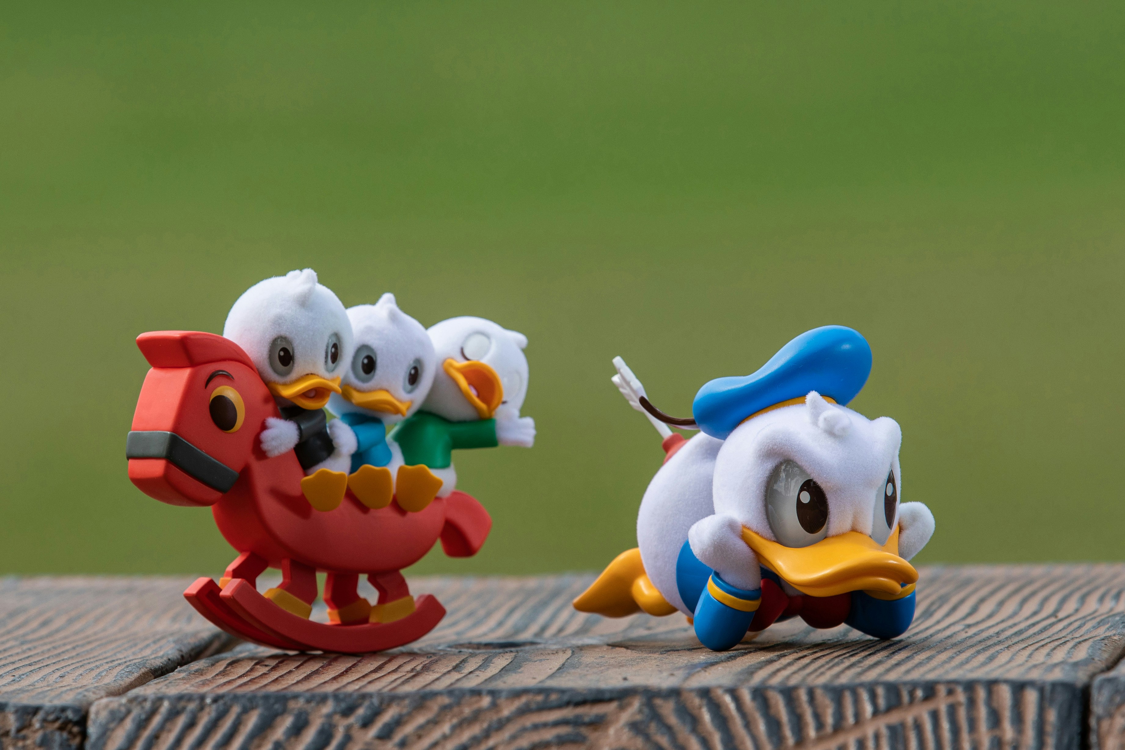 A couple of toy birds sitting on top of a wooden table