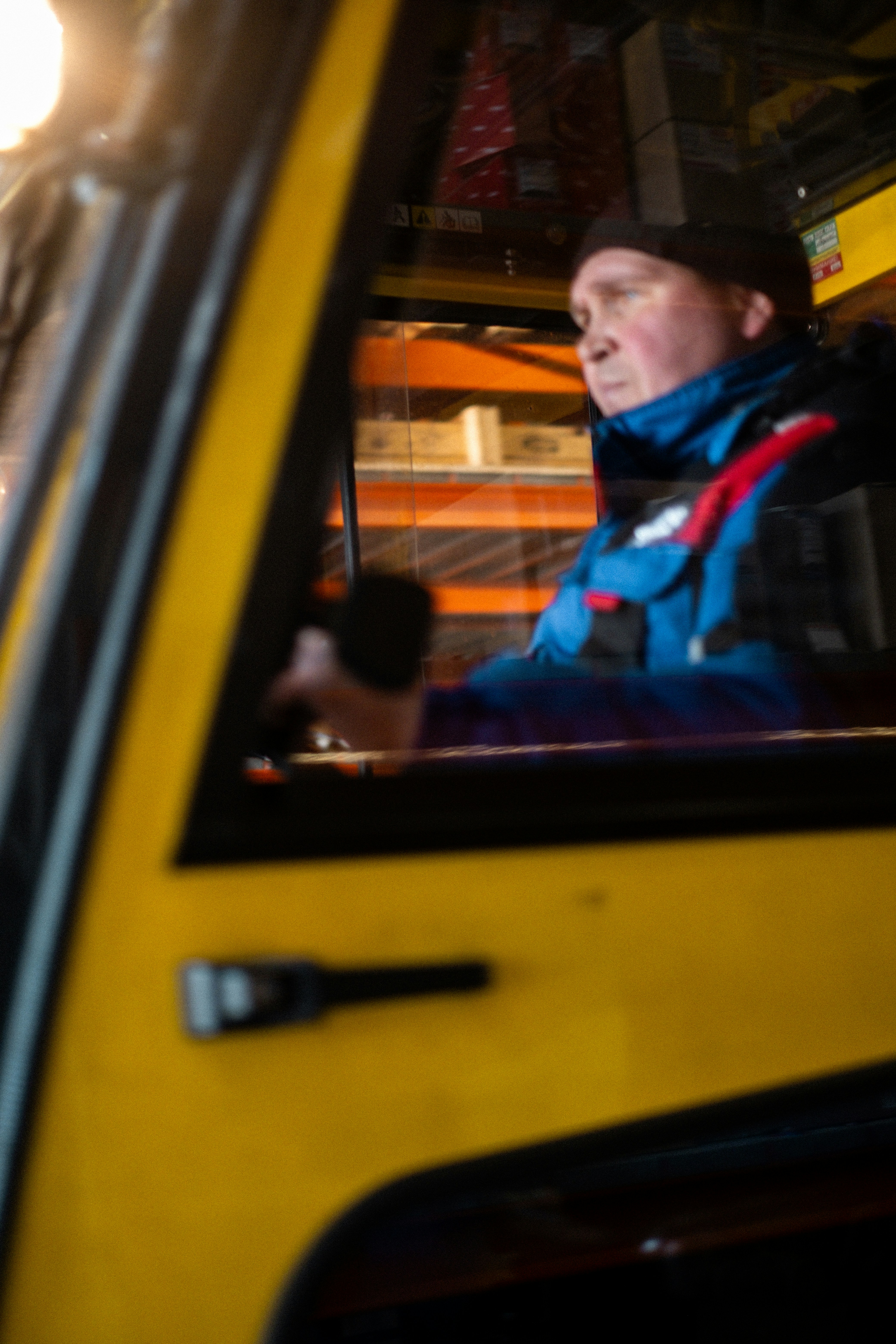 A man sitting in a yellow bus with his head out the window